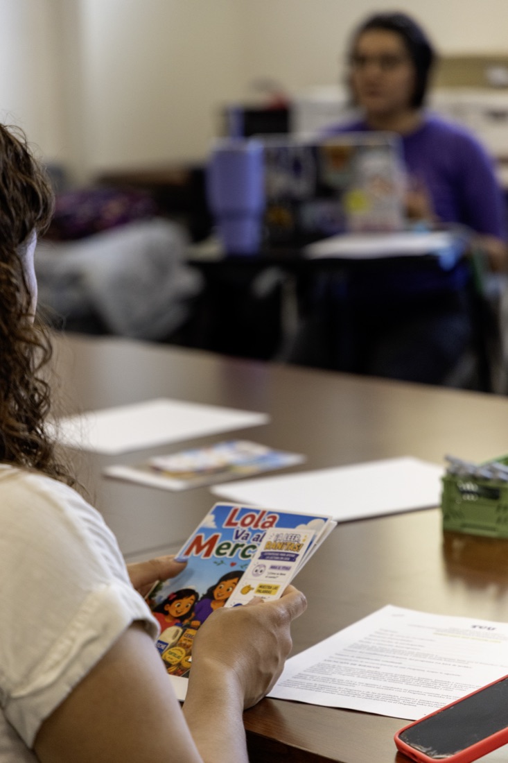 A participant holds a Spanish picture book during a family workshop
